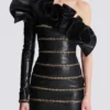 Asymmetrisches, figurbetontes Lederkleid mit Ketten Asymmetrisches, figurbetontes Lederkleid mit Ketten